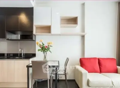 Modern apartment interior with stylish kitchen and cozy living area featuring a red-cushioned sofa.