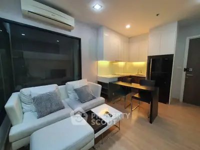 Modern open-layout living room with sleek kitchen and cozy seating area