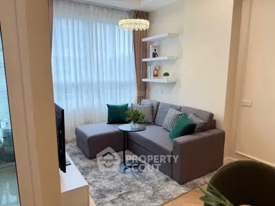 Cozy living room with modern gray sofa, chic decor, and natural light.
