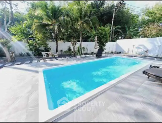 Luxurious private pool surrounded by lush greenery and modern patio design.