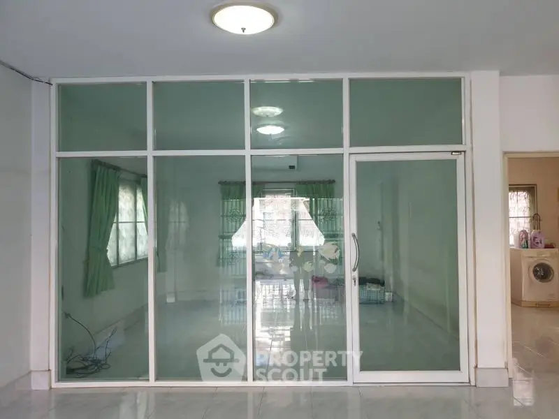 Spacious interior with glass partition and natural light, ideal for versatile living space.