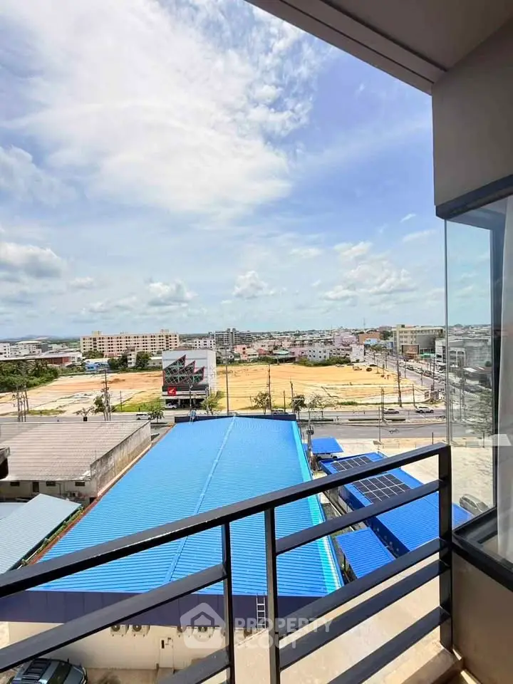 Stunning balcony view overlooking cityscape with blue rooftops and clear skies.