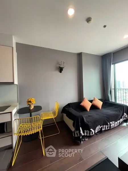 Modern living room with stylish decor and city view from large window.