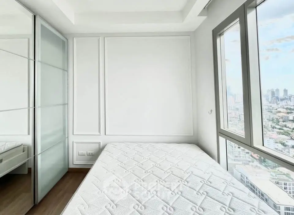 Bright bedroom with city view and large windows in modern apartment