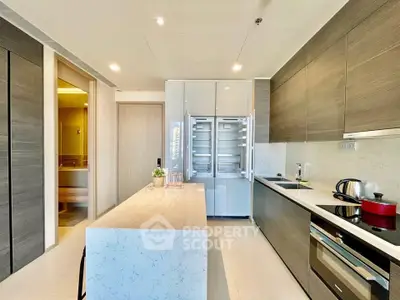 Modern kitchen with sleek design, island counter, and high-end appliances in luxury apartment.