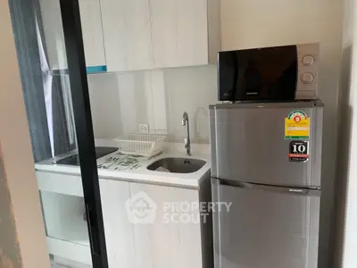Compact modern kitchen with sleek appliances and minimalist design, perfect for urban living.