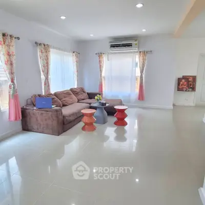 Spacious living room with modern sofa and bright windows in a stylish home.
