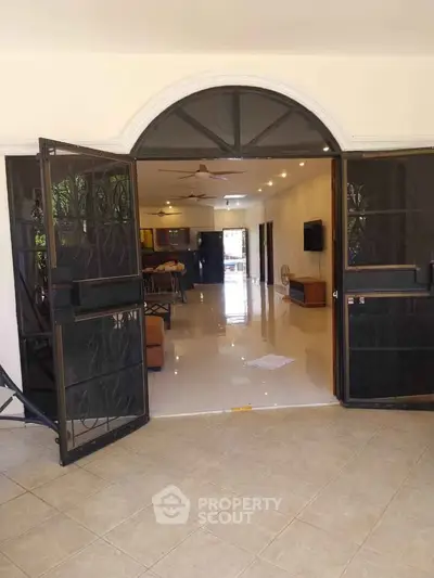 Spacious open-plan living area with elegant tile flooring and stylish decor, perfect for modern living.