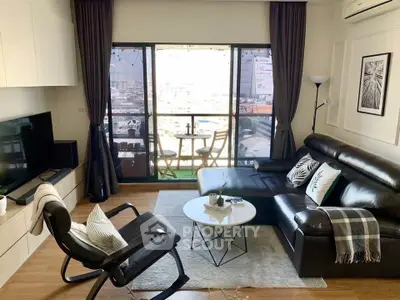 Modern living room with balcony view, stylish furniture, and natural light.