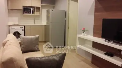 Modern apartment living room with open kitchen, featuring washing machine and sleek appliances.