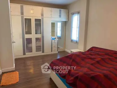 Spacious bedroom with modern wardrobe and cozy bed setup.
