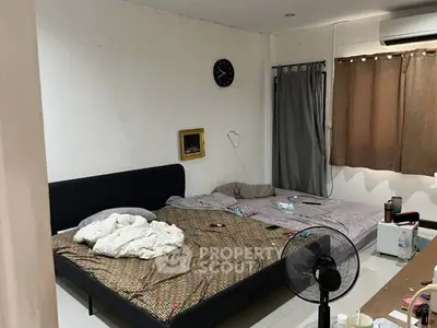 Cozy bedroom with two beds, air conditioning, and minimalist decor.
