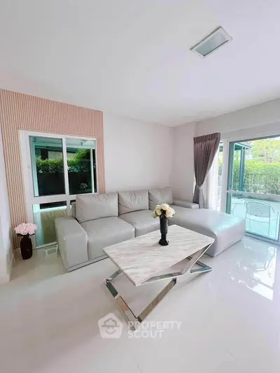 Bright and modern living room with stylish furniture and large windows.