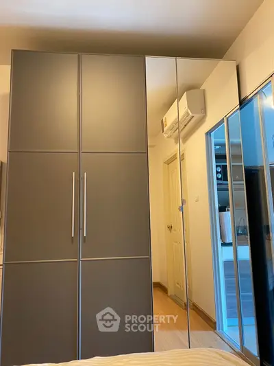 Modern bedroom with sleek wardrobe and mirrored doors