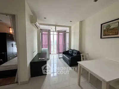 Modern living room with balcony access and sleek furnishings in a bright apartment.