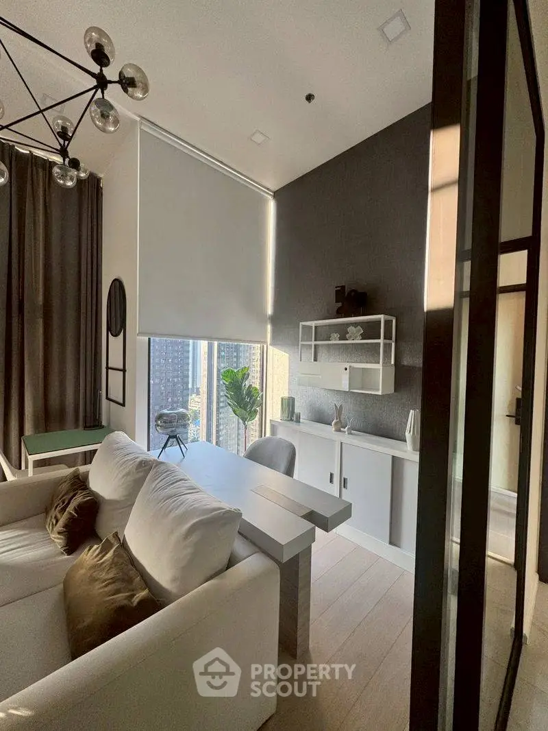 Modern living room with high ceilings and city view, featuring stylish decor and natural light.