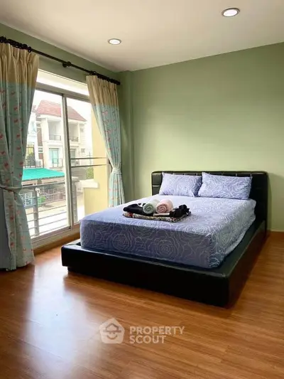Spacious bedroom with large window and modern decor in a stylish apartment.