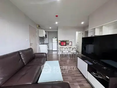 Modern living room with sleek furniture and open kitchen layout in a stylish apartment.