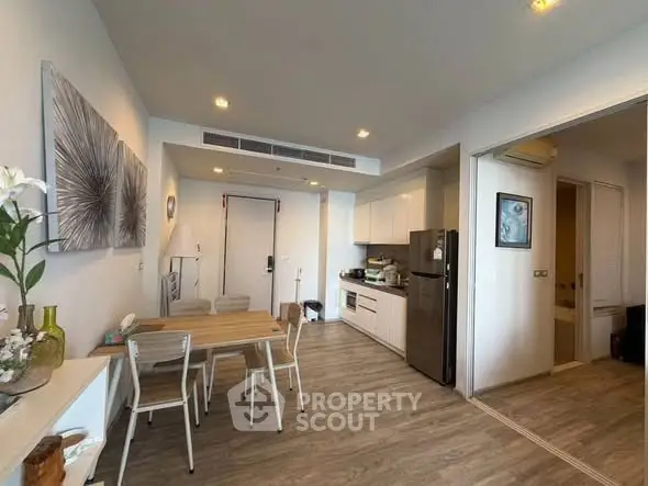 Modern open-layout kitchen and dining area with stylish decor and wooden flooring.