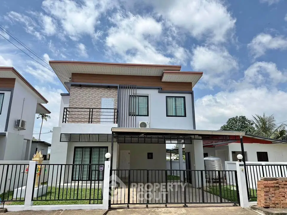 Modern two-story house with gated entrance and spacious driveway under a clear blue sky.