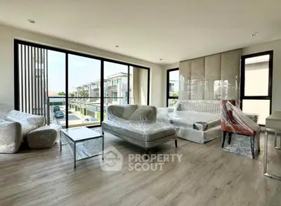 Spacious modern living room with large windows and stylish furniture in a luxury home.