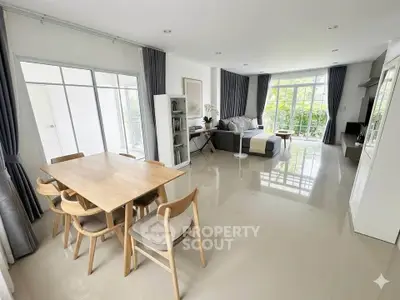 Spacious modern living room with elegant dining area and large windows for natural light.