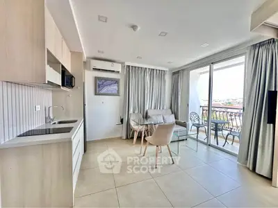 Modern open-plan living room with kitchen and balcony view, featuring sleek furniture and natural light.