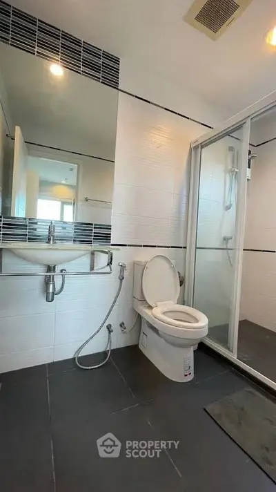 Modern bathroom with sleek shower and contemporary fixtures in stylish apartment.