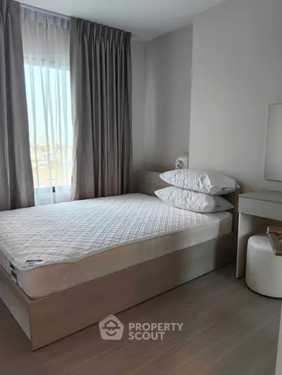 Cozy bedroom with natural light and modern furnishings, perfect for relaxation.