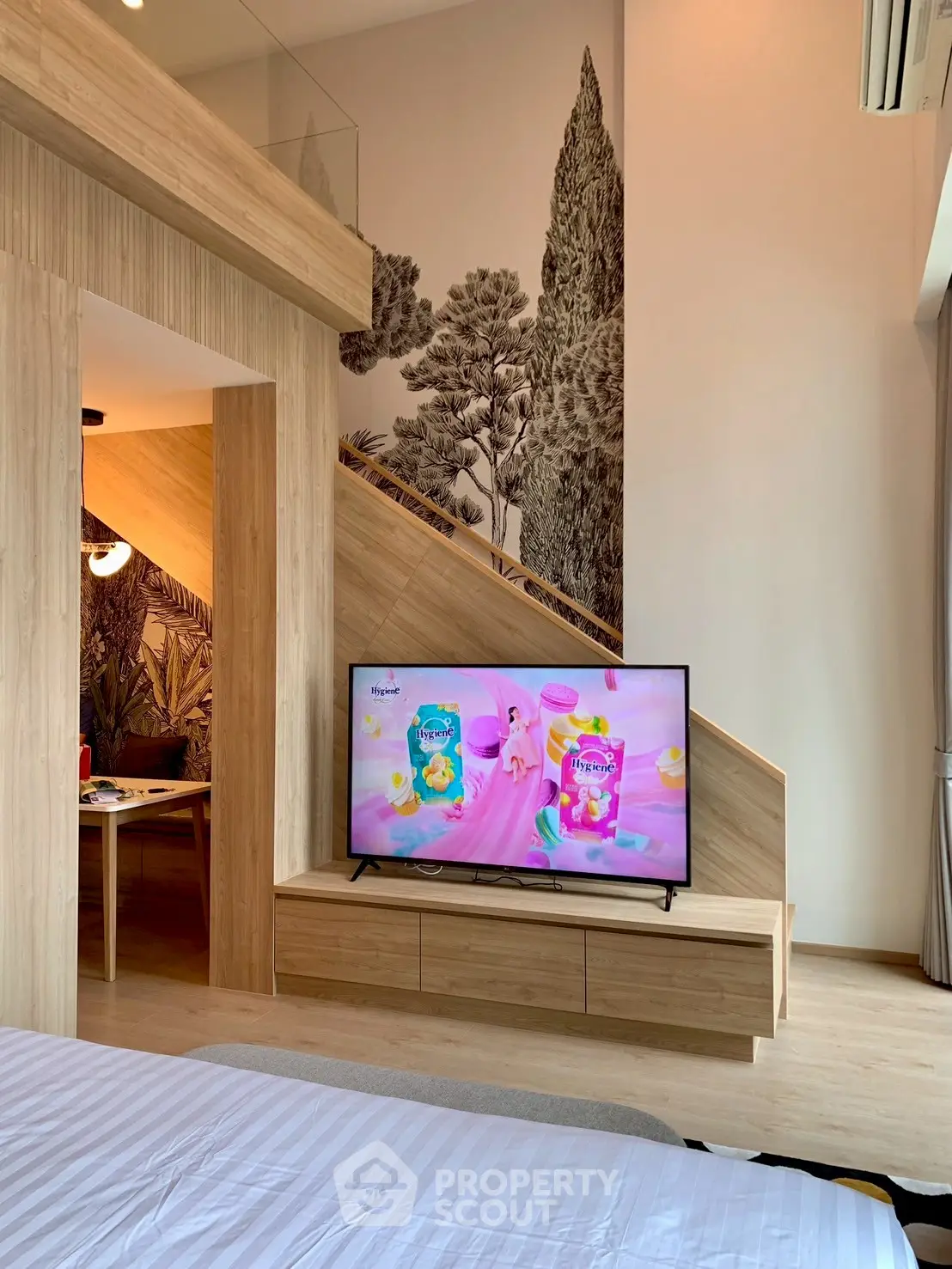 Modern bedroom with stylish wooden decor and large TV under staircase