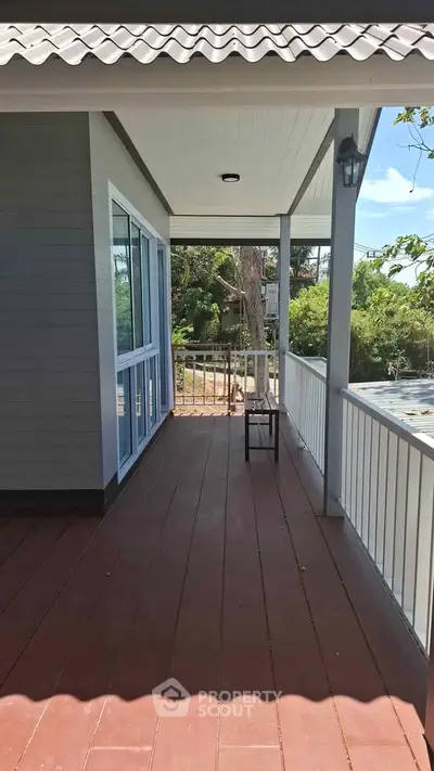 Charming balcony with wooden flooring and railing, perfect for relaxing outdoors.
