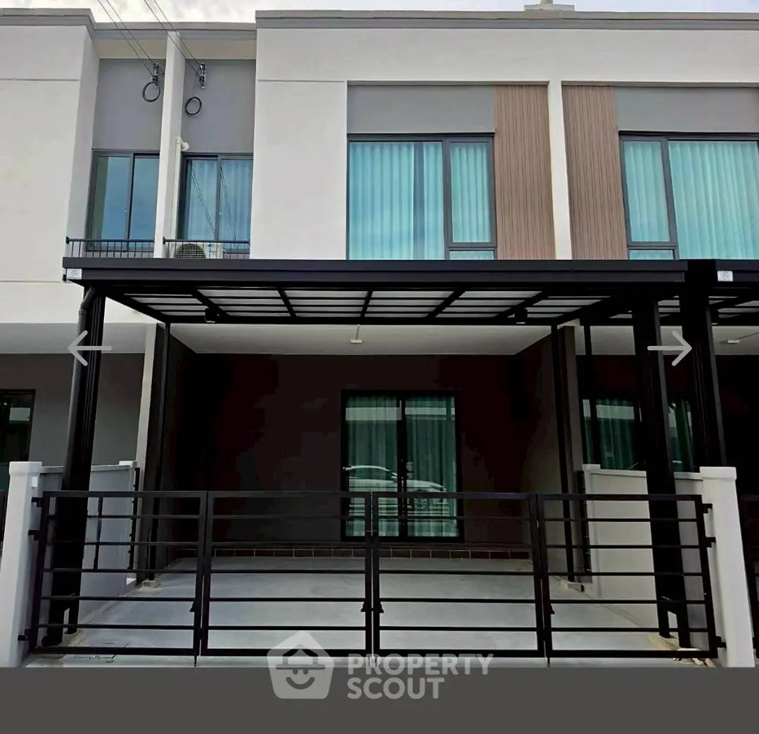 Modern townhouse exterior with sleek design and covered parking area.