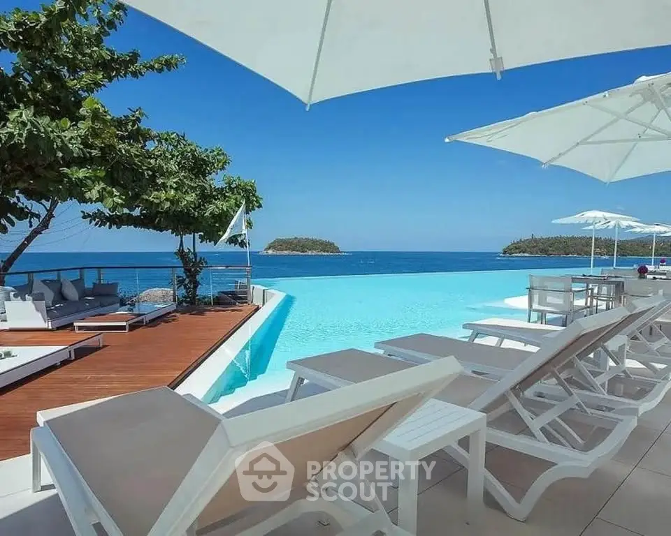 Luxurious beachfront pool area with stunning ocean views and elegant lounge chairs.