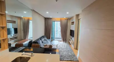 Modern living room with sleek design, featuring a cozy sofa, large TV, and floor-to-ceiling windows.