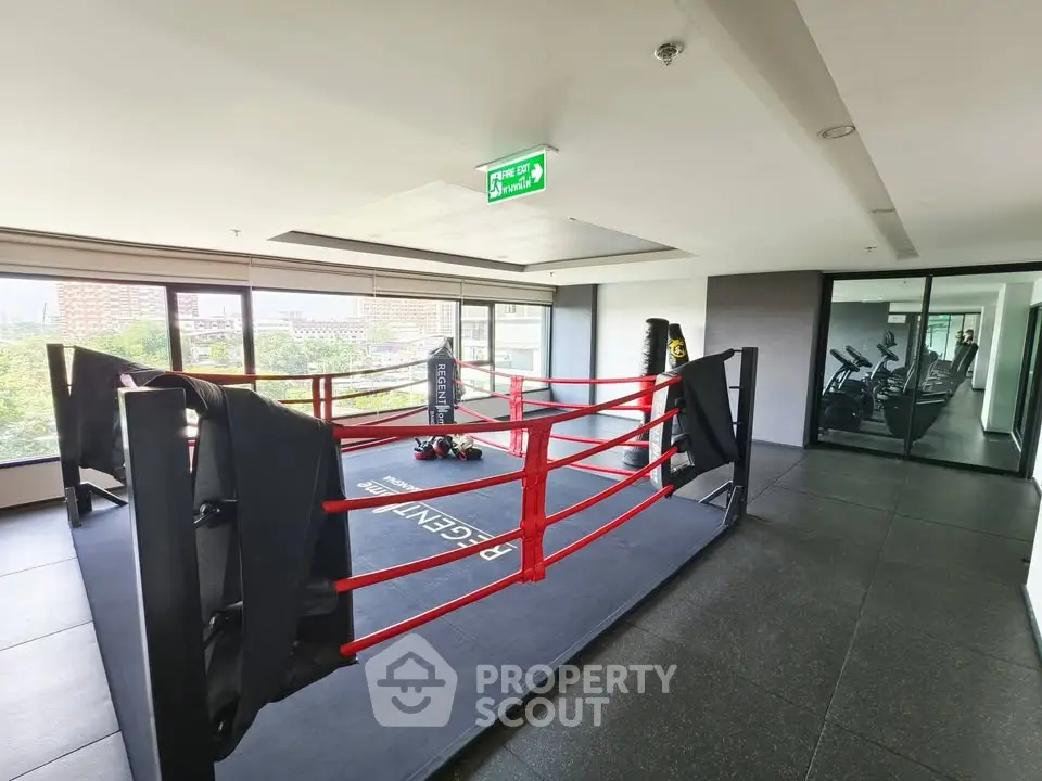 Modern gym with boxing ring and fitness equipment in a high-rise building