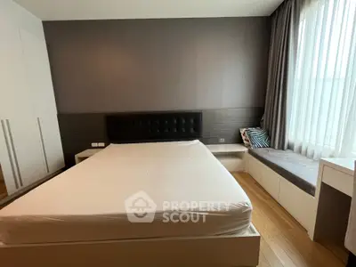 Modern bedroom with stylish decor and large window seating area