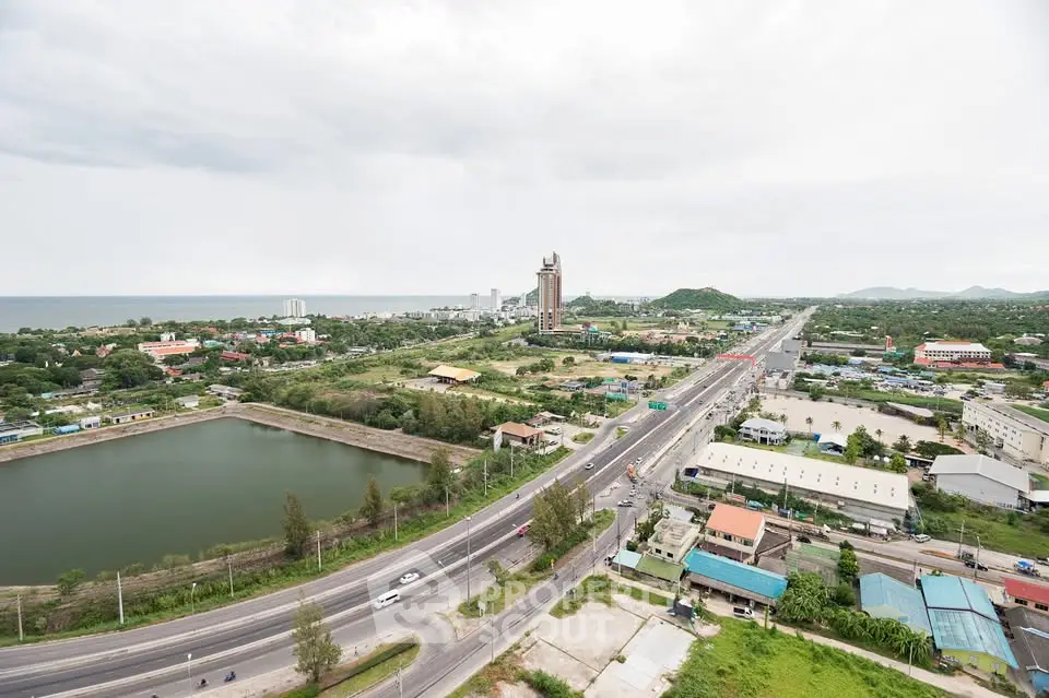 Stunning aerial view of coastal cityscape with roads, buildings, and lush greenery.