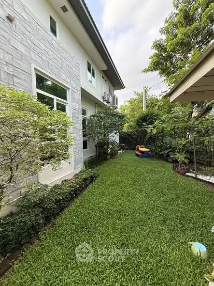 Charming garden view of a modern home with lush greenery and spacious lawn.