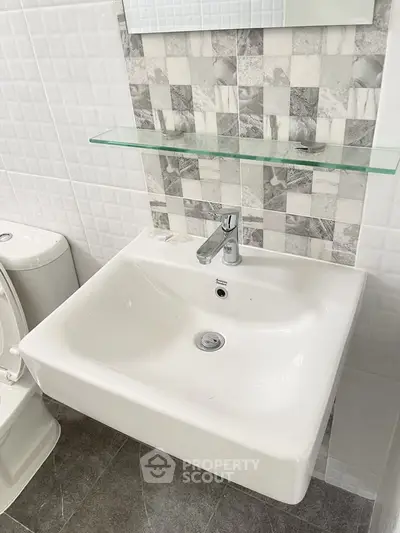 Modern bathroom with sleek white sink and stylish tile backsplash