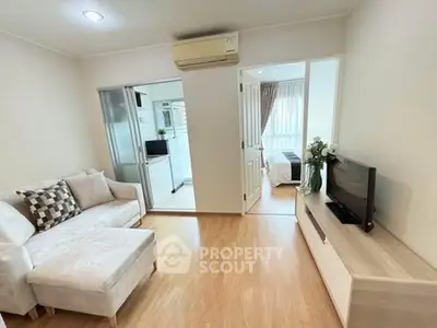 Cozy living room with modern decor and natural light, adjacent to bedroom and kitchen.