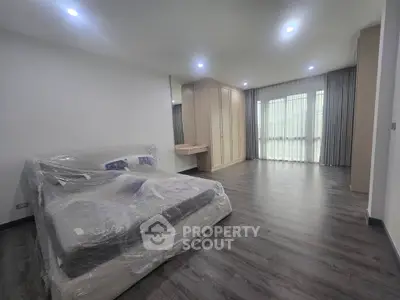 Spacious bedroom with modern design and large windows for natural light.