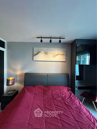 Modern bedroom with stylish decor and cozy red bedding