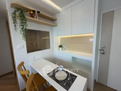 Modern kitchen with sleek cabinetry and cozy dining area in a compact apartment.