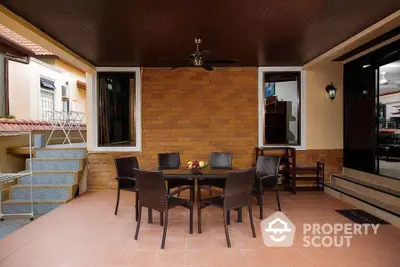 Charming outdoor patio with stylish dining set and warm brick wall, perfect for entertaining guests.