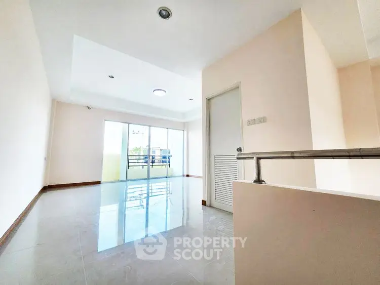 Spacious empty room with large windows and balcony access, perfect for customization.