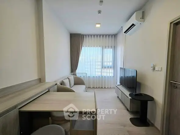 Modern living room with sleek furniture and large window, featuring air conditioning and neutral decor.