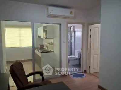 Modern apartment interior with kitchen and bathroom view, featuring sleek design and efficient layout.