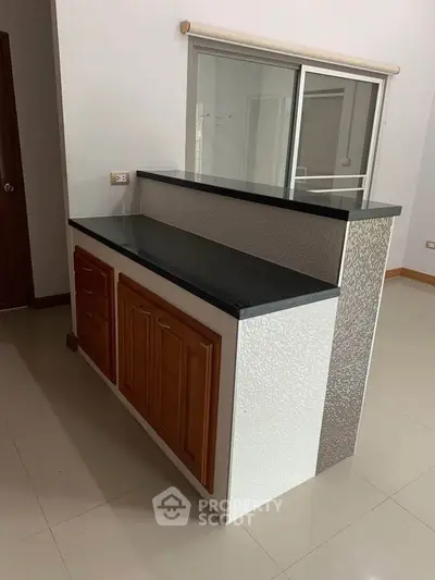 Modern kitchen with sleek countertop and wooden cabinets in a stylish apartment.