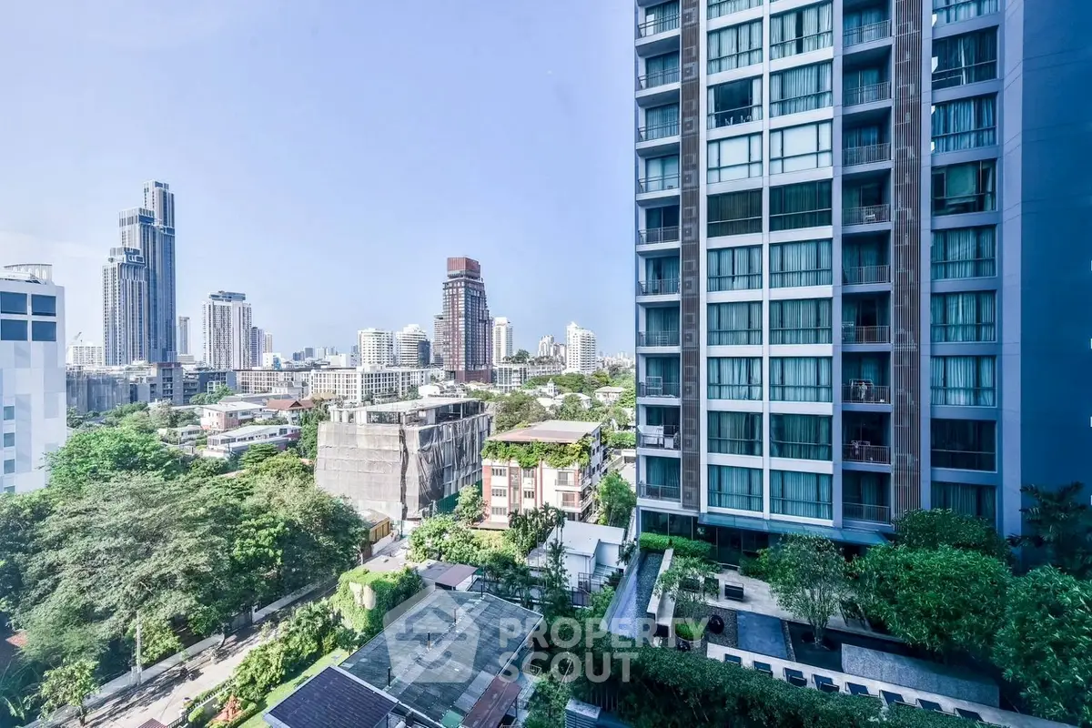 Stunning cityscape view from high-rise apartment with lush greenery and modern architecture.