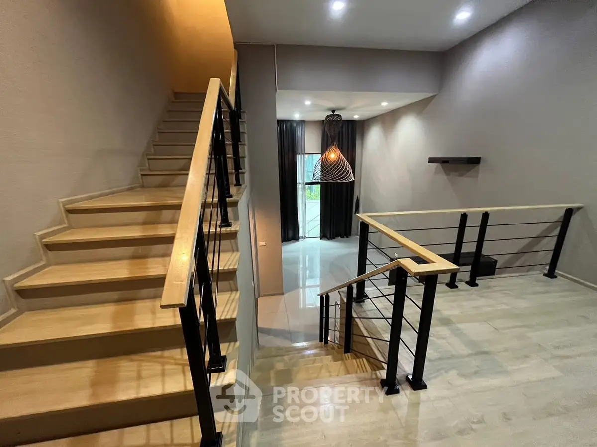 Modern staircase with sleek railing and stylish lighting in a contemporary home interior.